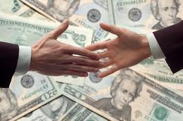 business handshake with money bills in background
